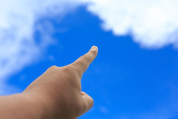 Foto mano tagliata che indica il cielo blu