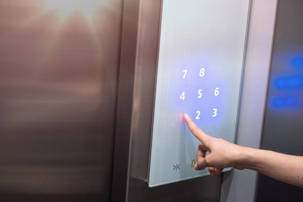 cropped hand pointing on number 1 in elevator