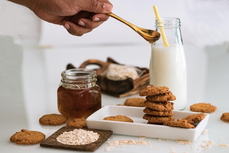 Photo cropped hand pouring honey on cookies