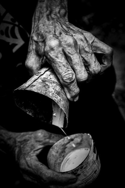 Photo cropped hand pouring liquid in container