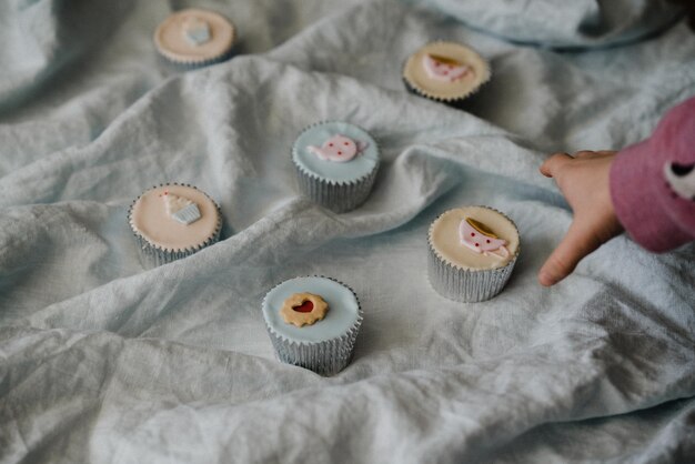 Photo cropped hand reaching cupcake on fabric