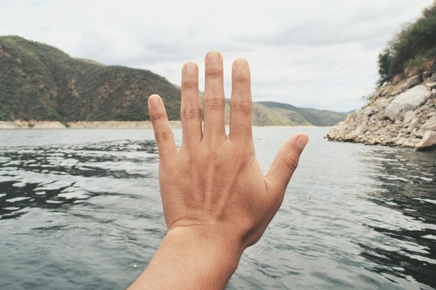 Foto la mano tagliata sul fiume contro il cielo