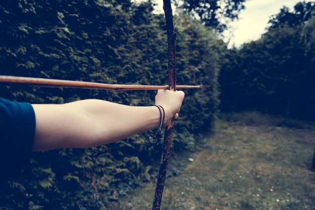 Cropped hand using bow and arrow