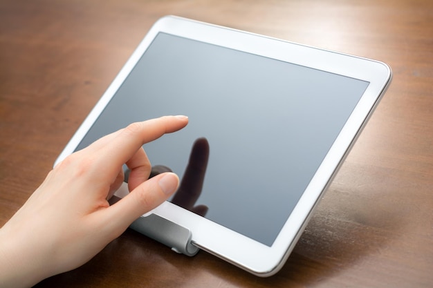 사진 나무 테이블 에 디지털 태블릿 을 사용 하여 절단 된 손