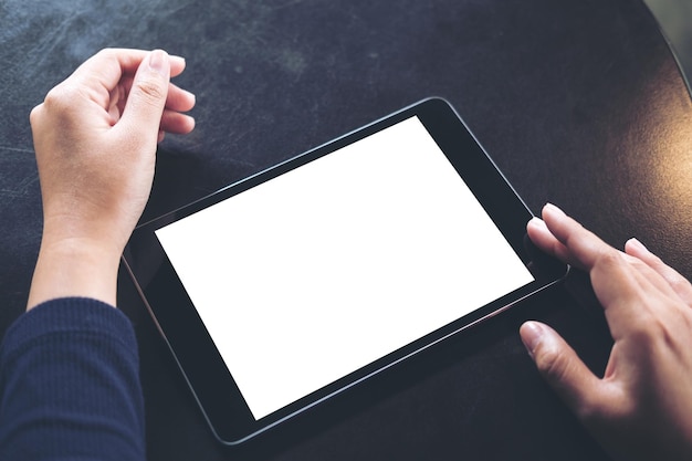cropped hand using digital tablet on table
