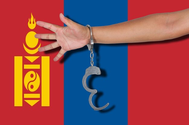 Photo cropped hand wearing handcuffs against flag