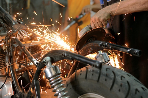 Foto parti di saldatura a mano tagliate in un laboratorio di riparazione di motocicli