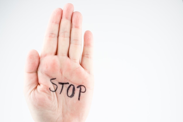 Photo cropped hand with stop text on palm against white background