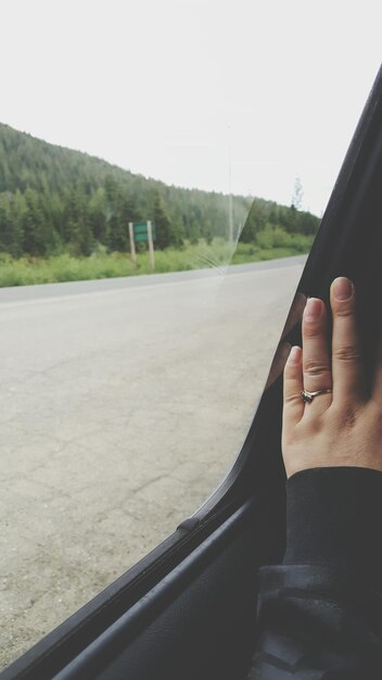 Photo cropped hand of woman by window in car