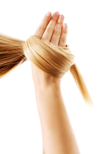 Photo cropped hand of woman holding blond hair against white background