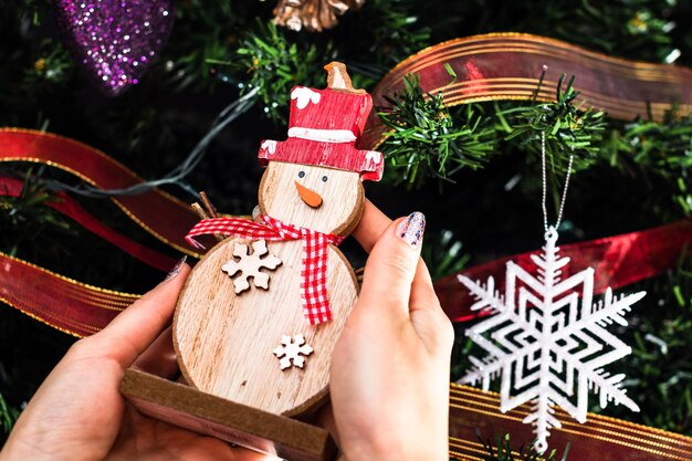 Foto mano tagliata di una donna che tiene l'albero di natale