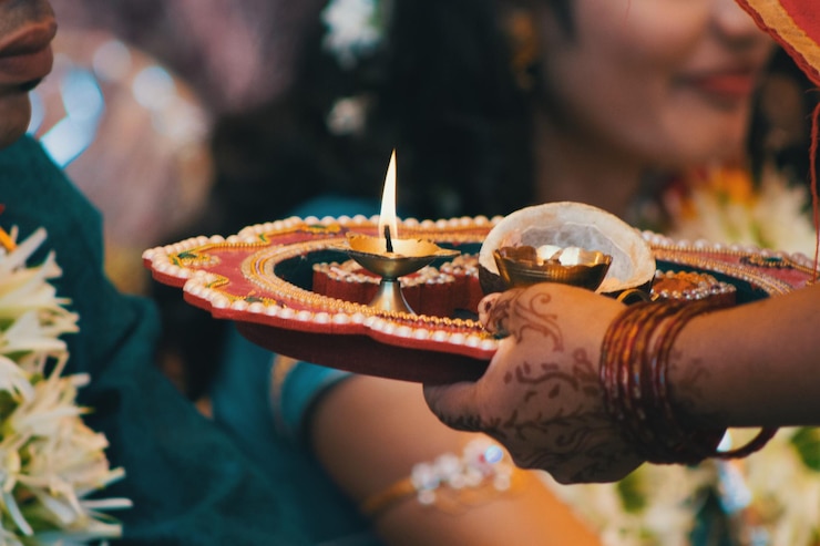 Photo cropped hand of woman holding diya in plate