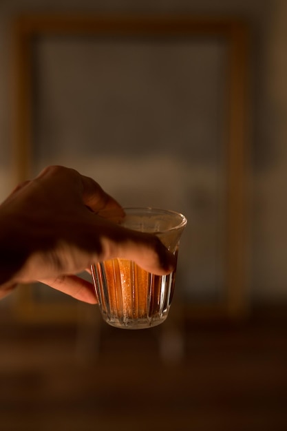 cropped hand of woman holding drink on table