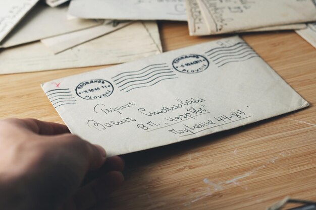 Photo cropped hand of woman holding letter on table