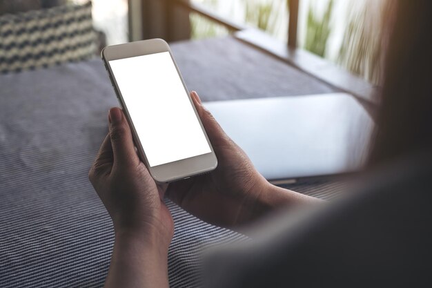 Photo cropped hand of woman holding mobile phone on table