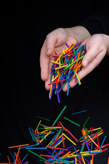 Foto mano tagliata di donna che tiene matite multicolori