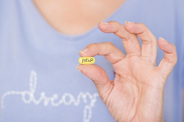 Cropped hand of woman holding pill