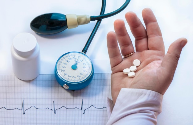 Cropped hand of woman holding pills over table