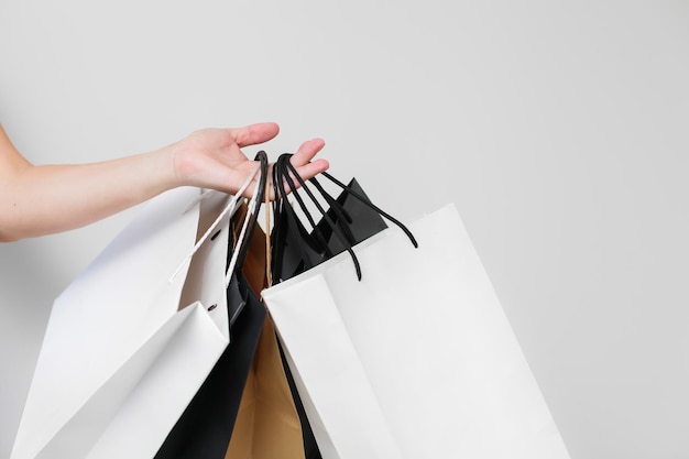 Photo cropped hand of woman holding shopping bags against white background