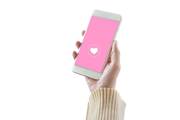 Cropped hand of woman holding smart phone with heart shape against white background