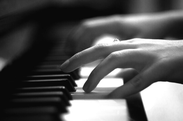 Foto mano tagliata di una donna che suona il pianoforte