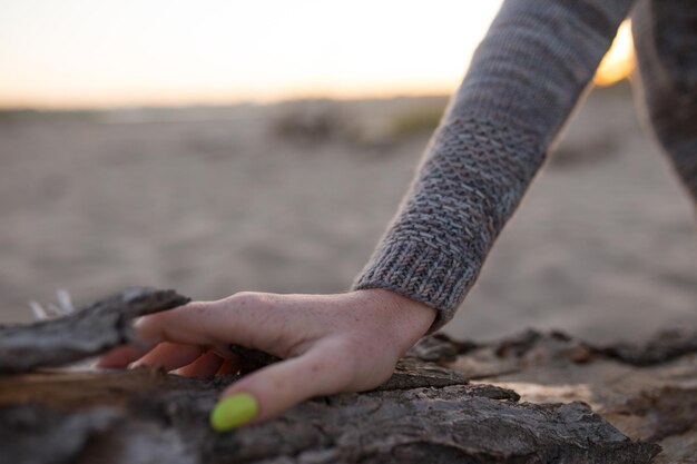 Photo cropped hand of woman on rock during sunset