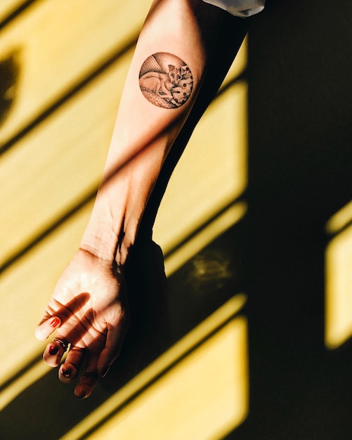 Cropped hand of woman showing tattoo