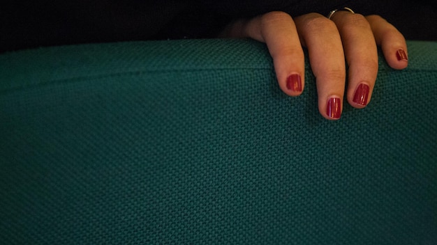 Cropped hand of woman on sofa at home