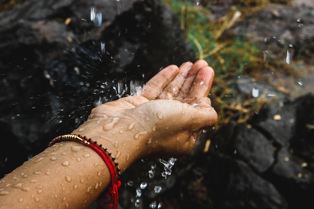 Cropped hand of woman splashing water outdoors