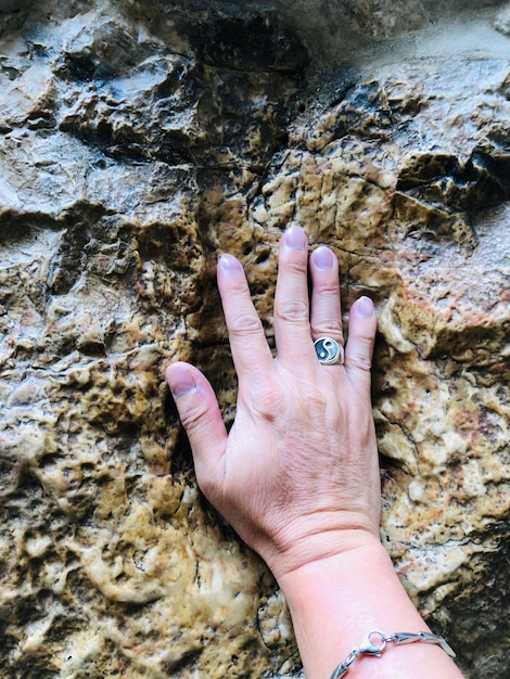 Photo cropped hand of woman touching rock