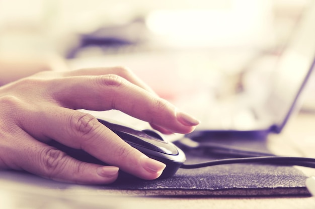 cropped hand of woman using computer mouse