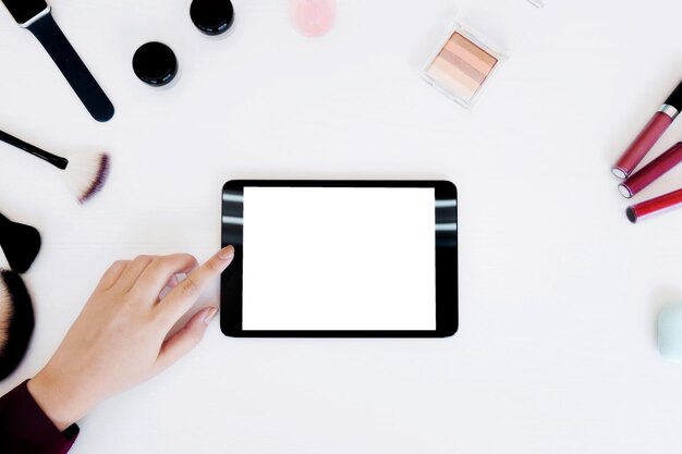 デジタルタブレットを机の上で使っている女性の切断された手