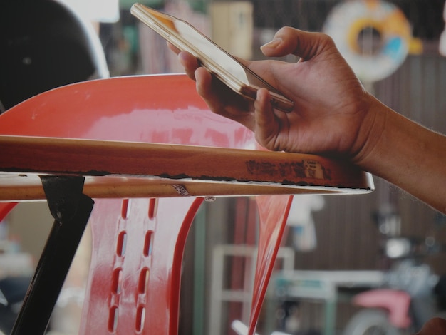 Photo cropped hand of woman using mobile phone at table