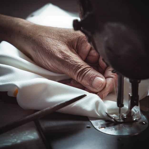 Photo cropped hand of woman using sewing machine