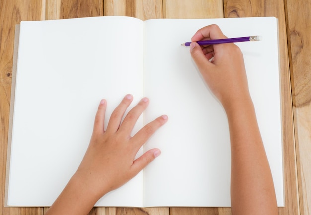 Foto mano tagliata di una donna che scrive in un libro