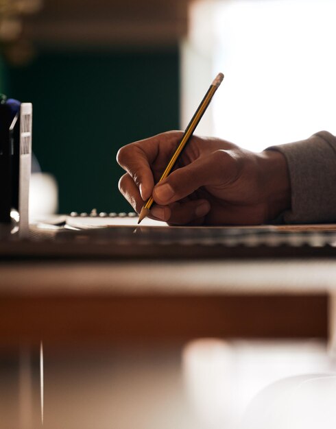 Cropped hand of woman writing in book