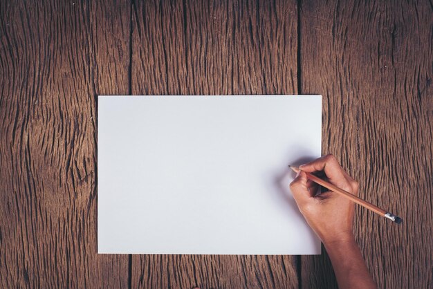 Foto scrittura a mano tagliata su carta bianca a un tavolo di legno