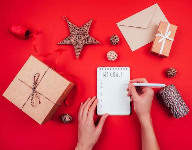 Cropped hand writing in book during christmas decoration