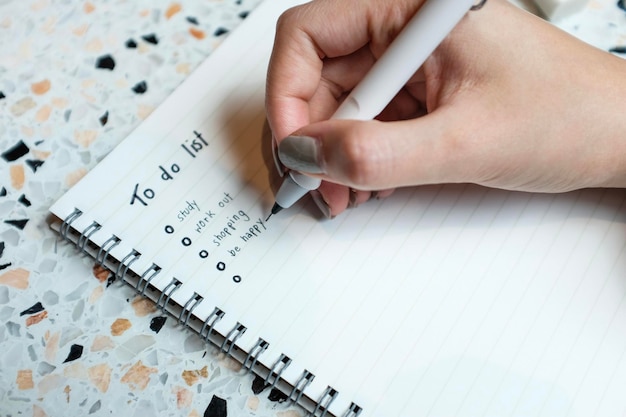 Cropped hand writing on book at table