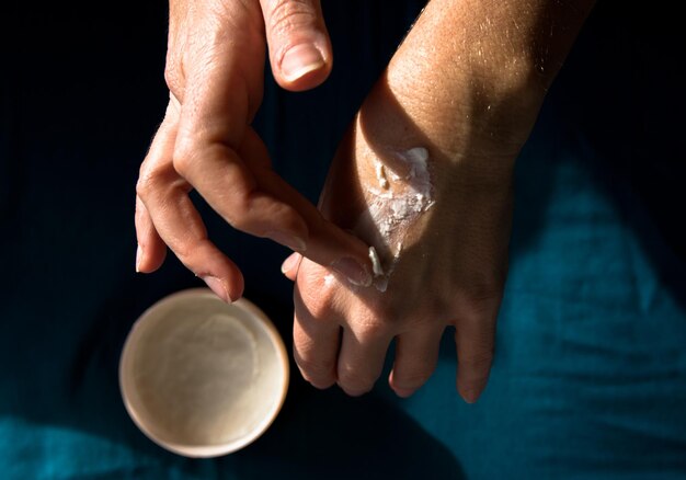 Cropped hands applying cream at home