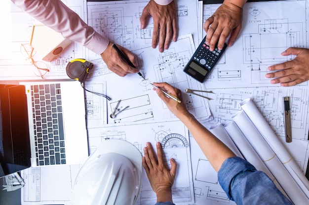 Photo cropped hands of architects with blueprints working on desk