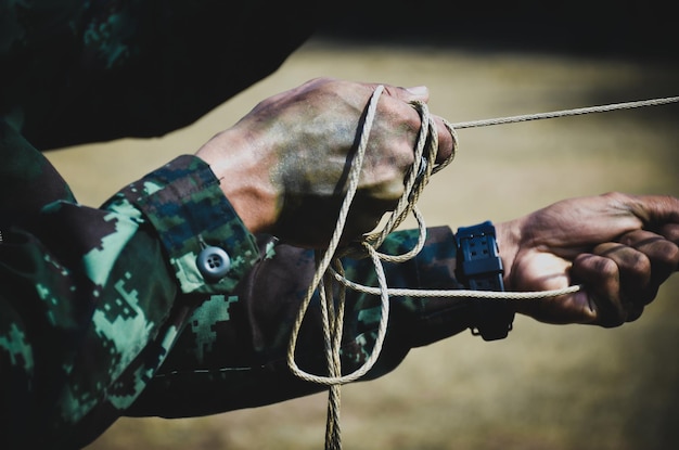 Photo cropped hands of army soldier pulling rope