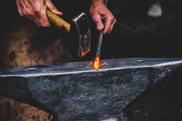 Photo cropped hands of blacksmith working at industry