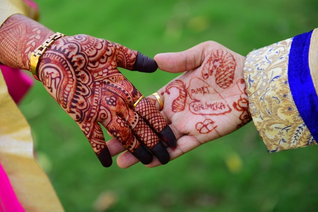 Cropped hands of bride and groom with henna tattoo