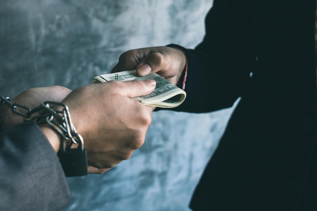 Photo cropped hands of business people holding money against wall