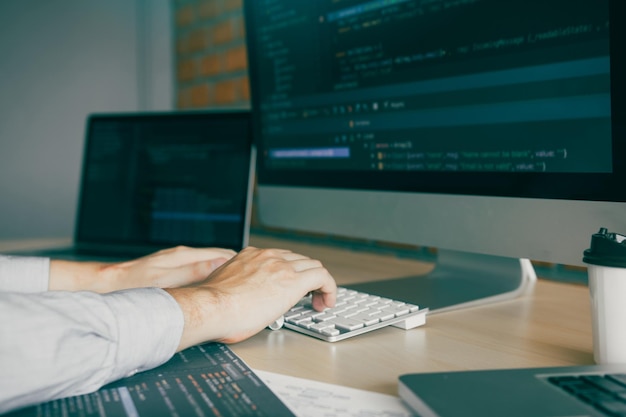 cropped hands of business person using computer on desk