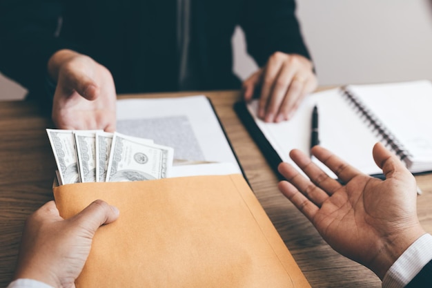 Cropped hands of businessman bribing male colleague in office