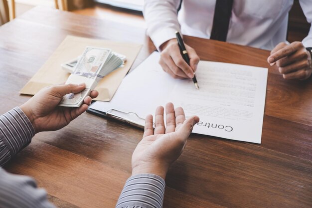 Photo cropped hands of businessman bribing male coworker in office