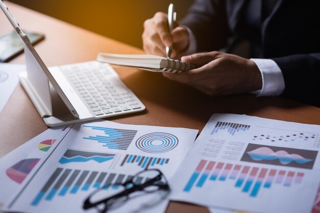 Photo cropped hands of businessman holding book at desk in office