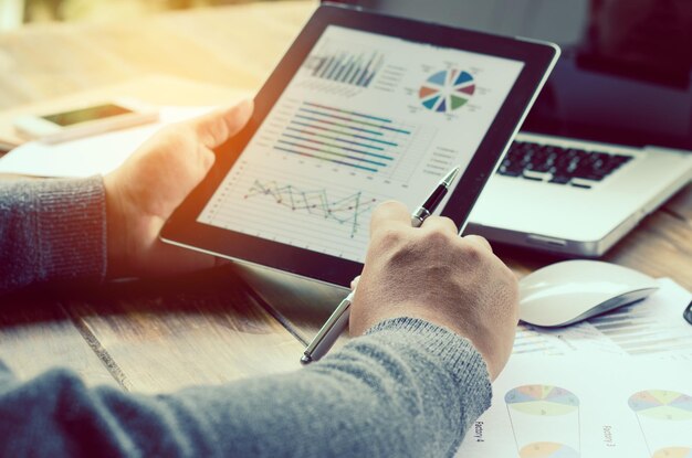 Photo cropped hands of businessman using digital tablet at desk